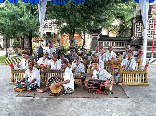 A group of gamelan musicians filling the air with traditional rhythms.