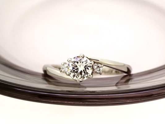包み込むようなラインを描くアームが優しい雰囲気のダイヤモンドリング。