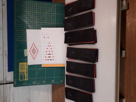 Vue sur les multiples platines composées de placages noir-rouge-blanc destinées à façonner le motif en losange des rosaces typiques des guitares d'Hervé Lahoun