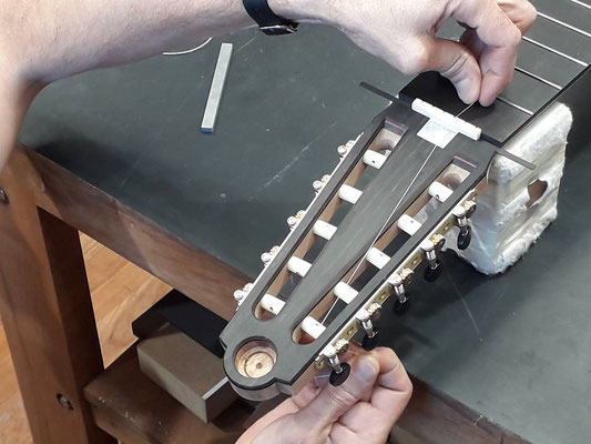 View of the final shaping work on the headstock of a 10-string guitar in Hervé Lahoun-H441guitare's workshop