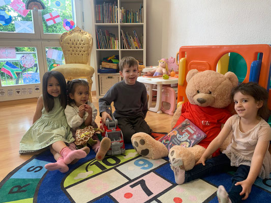 Children enjoying circle time with the Custom Kids mascot, Zilla, during English playgroup in Ehrendingen.