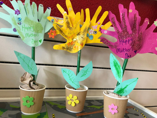 Handprint flower crafts made by children at Custom Kidsfor Mother's Day.