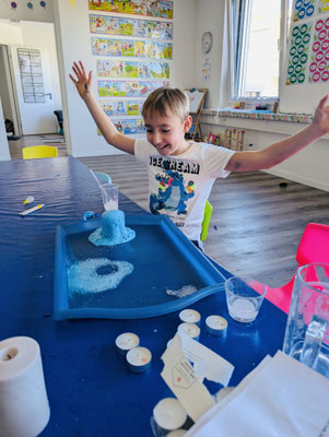 Child exploring a bubbling chemical reaction during Custom Kids Science Club.