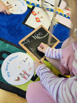 Children practicing words with mini chalkboards