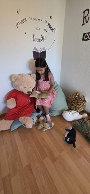 Child reading to Zilla, Custom Kids mascot.