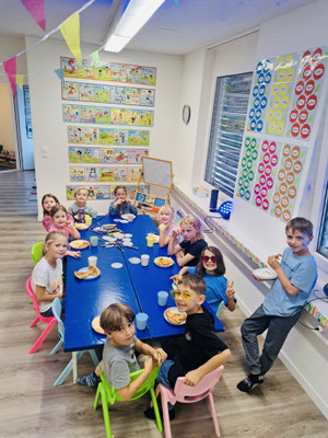 Children enjoying pizza together during a birthday disco party.