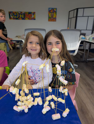 Children proudly showing their completed STEM engineering challenge.