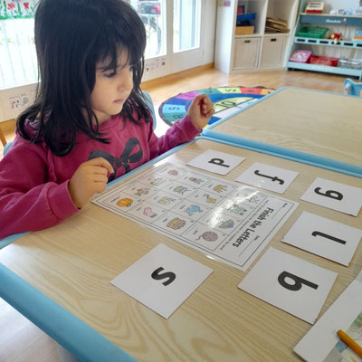 Child practising early reading and letter recognition during a Custom Kids English class in Ehrendingen.