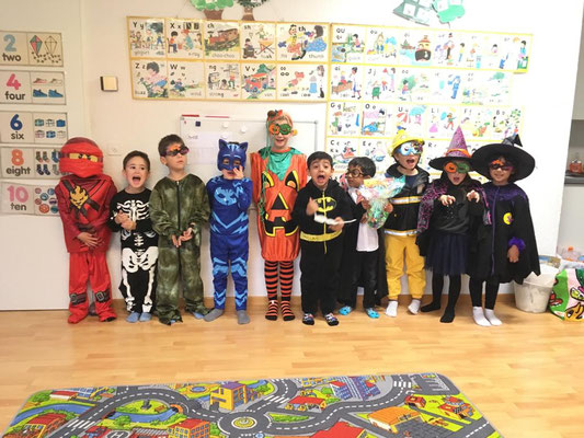 Children dressed in Halloween costumes posing together at a Custom Kids party.
