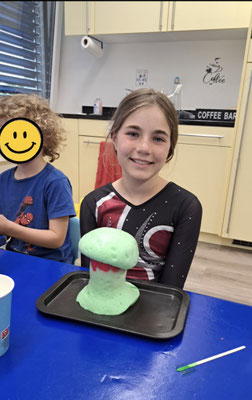 Child proudly showing the results of a Science Club experiment.