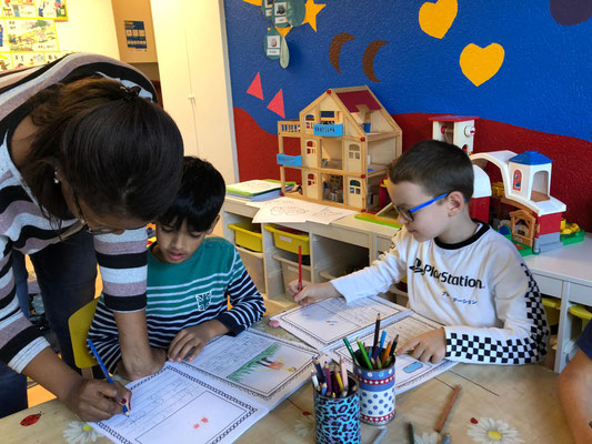 Custom Kids teacher helping a child with spelling