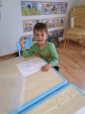 Child proudly completing an English learning activity.