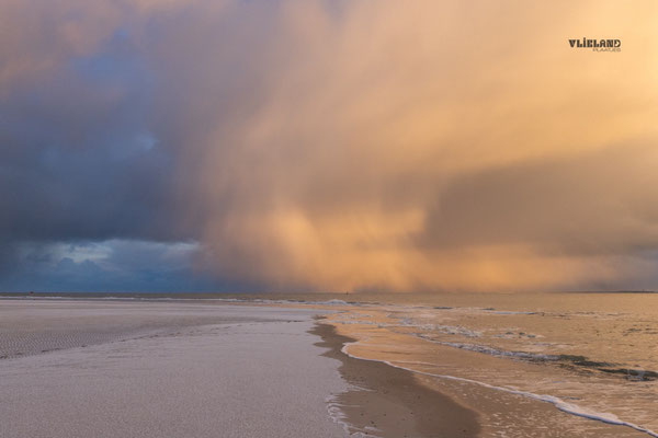 Geel verlichtte Buienwolk door de zonsopkomst, 6 januari 2026