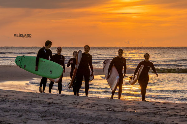 Surfers tijdens zonsondergang, 6 juni 2025