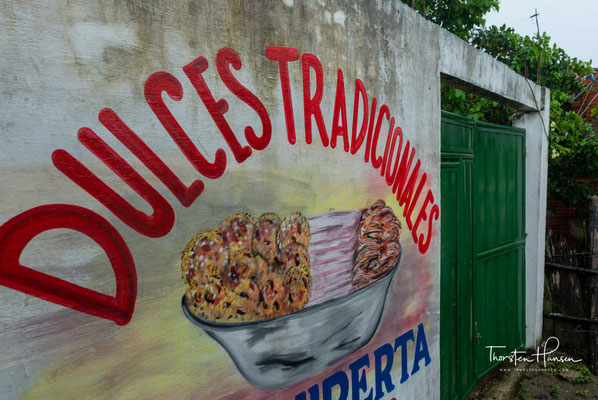 In den  kolonialen Straßen von Cartagena de Indias trifft man auf eine auffällige Gruppe von Frauen, gekleidet in bunte Röcke und Turbane mit Schals.