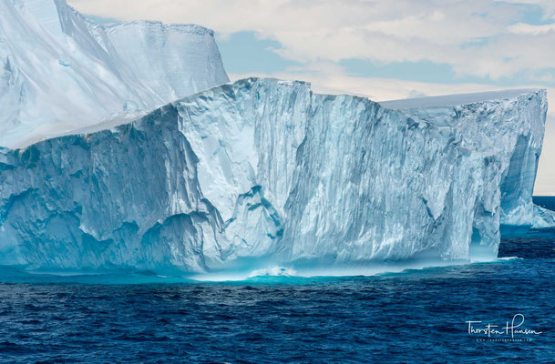 Im Allgemeinen sind Eisberge weiß. Die weiße Farbe wird durch die Reflexion des Lichtes an der im Eis eingeschlossenen Luft hervorgerufen