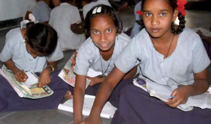 Girls sitting on the floor in their school in India.