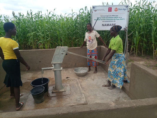 Three women getting water from the new wells of the joint project of the GoodTextiles Foundation and Cotton made in Africa. ©Aid by Trade Foundation