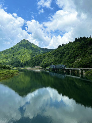 2024年7月27日、蒲生岳をバックに只見川沿いを走る只見線