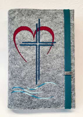 Stickmotiv "Kreuz Herz Welle" auf hellgrau meliertem Filz in beere-petrol, hier mit einem Straßsteinchen