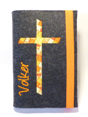 Stickmotiv Mosaik-Kreuz in orange-gelb mit Gummi orange auf Filz in anthrazit mit Schriftart Angelina (fett)