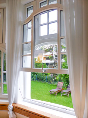 Hochwertiges Vertikalschiebefenster von Sorpetaler leicht geöffnet mit Blick in den Garten