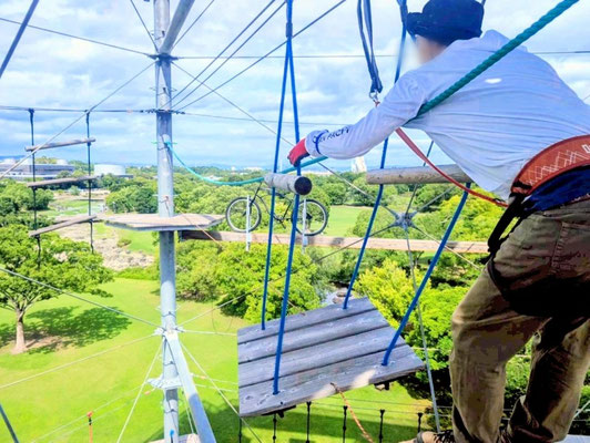 大阪のメンズマッサージ「forest hands」セラピストが、万博記念公園の空中アスレチックで空中ブランコなどのアトラクションに挑む爽快なポートレート。