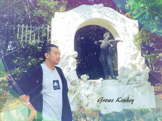 大阪のゲイマッサージGrows（グローズ）の男性セラピストKouhey（コウヘイ）。彫像のある庭園を背景にした横顔の紹介画像。エキゾチックで大人な雰囲気。
