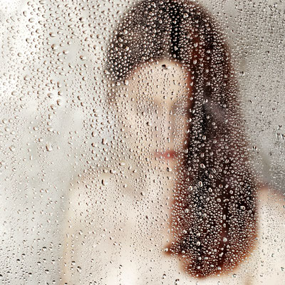 Manuela Deigert Projekte Melancholisches Selbstportrait hinter einer Scheibe mit Wassertropfen