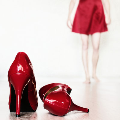 Manuela Deigert Projekte Selbstportrait mit rotem Negligee sowie ein stehender und ein umgefallener High Heel im Vordergrund