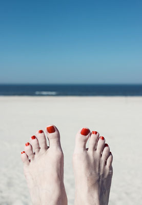 Manuela Deigert Meeresfarben, malerisches Meer, Relax, zwei Füße am Meer, im Hintergrund ein Bokeh aus Strand und Blick auf die Nordsee bei Langeoog