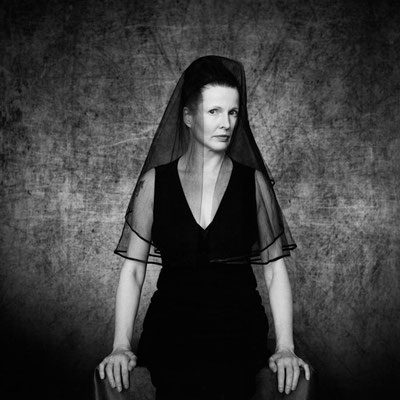 Manuela Deigert Mittelformat schwarzweißes Selbstportrait sitzend mit schwarzem Schleier