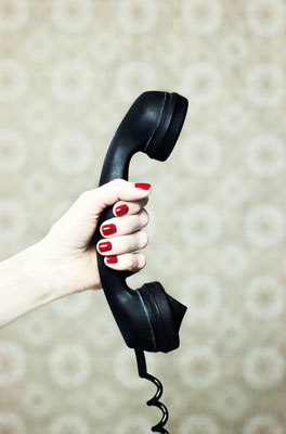 Manuela Deigert Projekte Hand einer Frau mit einem alten schwarzen Telefonhörer im Vintage Stil