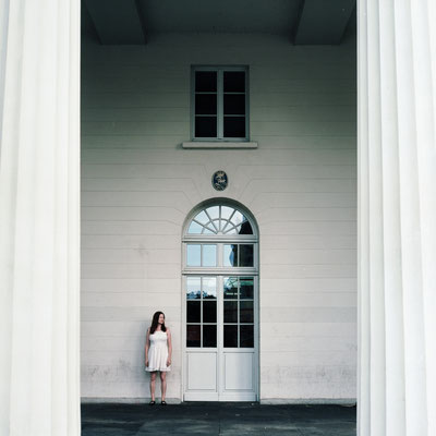 Manuela Deigert Oldenburg Mittelformat Frau zwischen einem Gebäude mit Säulen
