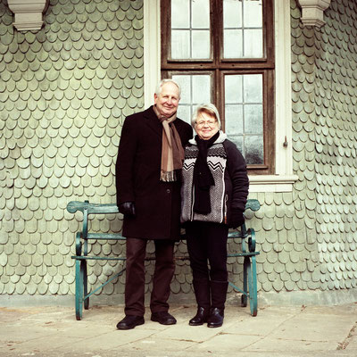 Manuela Deigert Mittelformat Ältere Frau mit älterem Mann zusammen vor einem Fenster und Wand aus grünem Schiefer