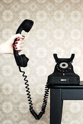 Manuela Deigert Projekte Hand einer Frau mit einem alten schwarzen Telefonhörer und Telefon im Vintage Stil