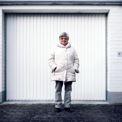 Manuela Deigert Mittelformat ältere Frau vor einer Garage