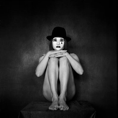 Manuela Deigert Mittelformat Nude schwarzweißes Selbstportrait in sitzender Pose mit Harlekinmaske
