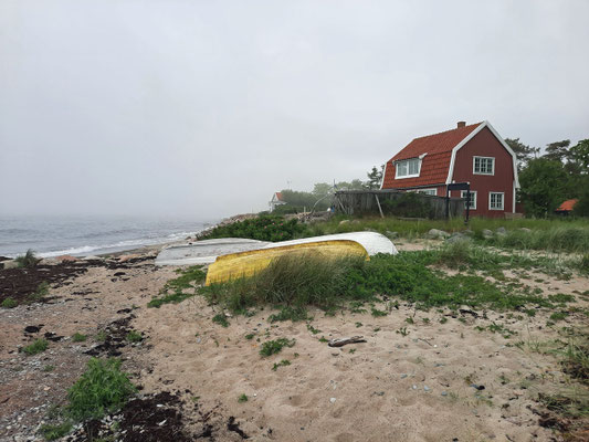Bei Nebel wirkt die Szenerie leicht mystisch: Boote liegen vor einem Holzhaus am Ufer. Foto: Kai-Uwe Ruf