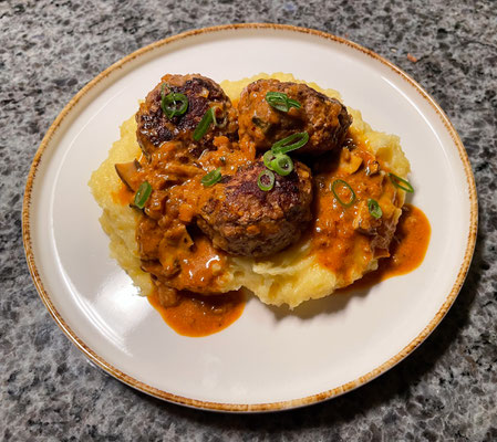 Fleischpflanzerl in Bratensoße auf Kartoffelpüree