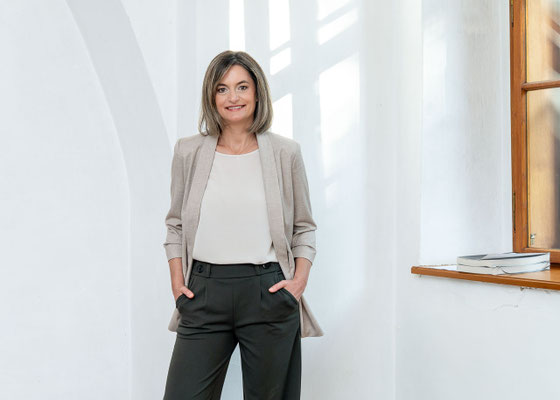 Selbstbewußte Businessfrau in die Kamera blickend.