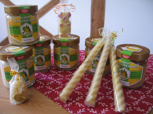 Sechs Gläser mit verschiedenen Honigsorten und Kerzen