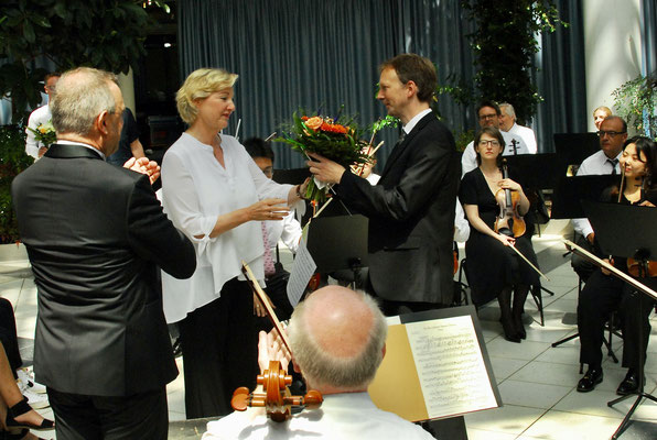 Musikschulleiterin Sabine Fiebig-Fechtner übergibt Dirigent Aurélien Bello Blumen