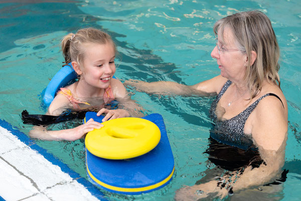 Kind übt mit Schwimmbrett und Auftriebshilfe im inklusiven Schwimmkurs des BSV Achim und verbessert spielerisch seine Technik.