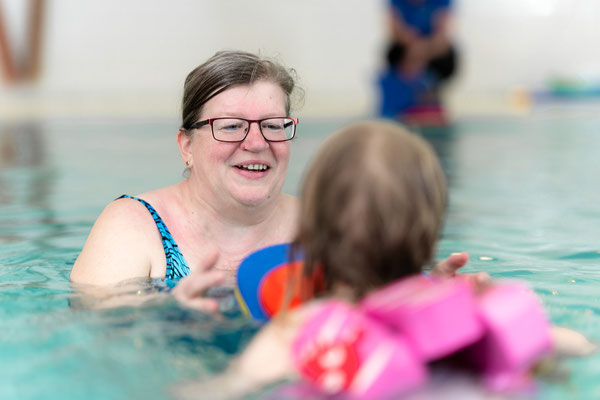 Kind übt mit Schwimmbrett und Auftriebshilfe im inklusiven Schwimmkurs des BSV Achim und verbessert spielerisch seine Technik.