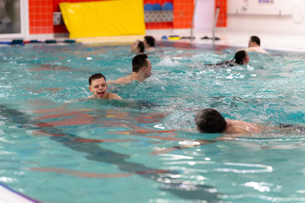 Jugendliche und Erwachsene der inklusiven Schwimmgruppe Belugas trainieren gemeinsam ihre Schwimmtechnik im Becken.