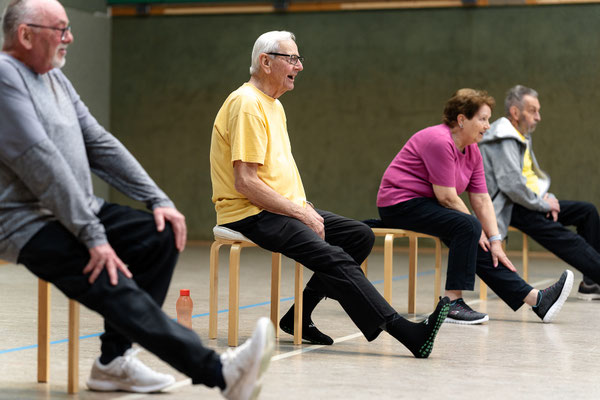 Lungensport beim BSV Achim: Gruppe sitzt auf Hockern und streckt abwechselnd die Beine nach vorne.