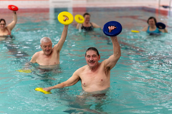 Teilnehmende der BSV Achim Wassergymnastik-Reha-Sport-Gruppe trainieren mit Auftriebsscheiben im Wasser zur Verbesserung von Beweglichkeit und Kraft.