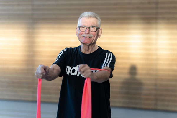 Teilnehmer des Herz- und Rehasports beim BSV Achim führt eine Kräftigungsübung mit Theraband zur Stärkung der Muskulatur durch.
