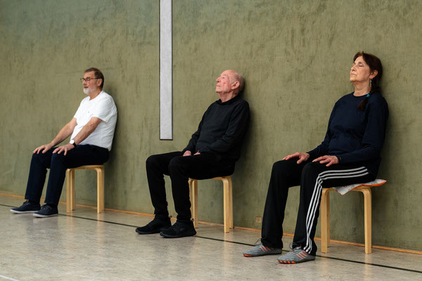 Entspannungsphase beim Lungensport des BSV Achim: Teilnehmende sitzen ruhig auf Hockern an der Wand und schließen die Augen zum Ausklang der Stunde.